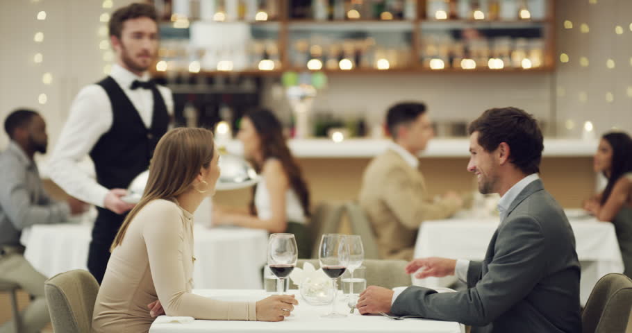 Love, toast or couple in restaurant in celebration of a happy marriage anniversary at dinner at night. Waiter, romantic man or woman fine dining eating food bonding or drinking wine on valentines day | Shutterstock HD Video #1104290997