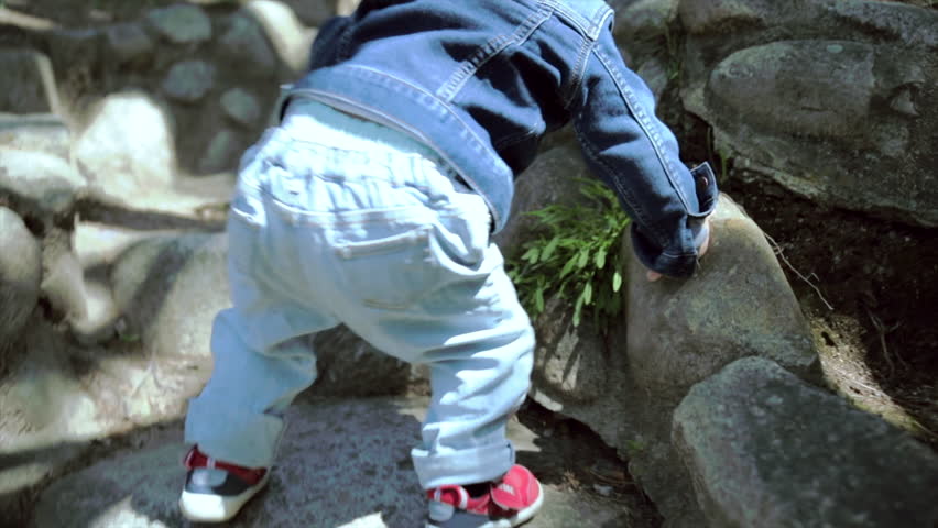 Little boy taking his first steps in a Japanese garden