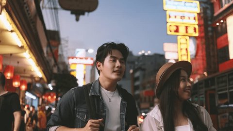 Young Asian couple enjoy and have fun outdoor lifestyle together in street market on summer holiday vacation in bangkok, thailand. Happy man and woman feeling surprise about how beautiful the city is 庫存影片