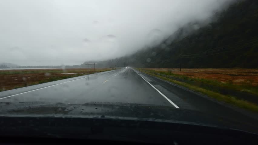 in the car to drive in heavy rain, wipers clean the windshield glass in alaska Royalty-Free Stock Footage #1104294941