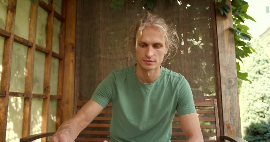 Young man having tea ceremony in oriental gazebo