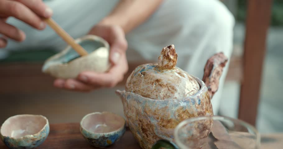 Young man having tea ceremony in oriental gazebo