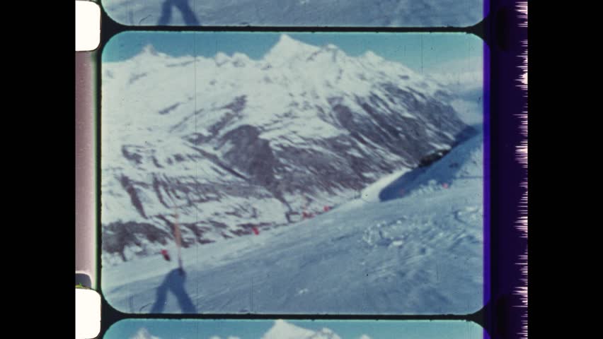 1989 Chamonix, France. Point of View of a Skier racing downhill on Alps Mountain slope. POV with skis in foreground. 4K Overscan of vintage archival 16mm film