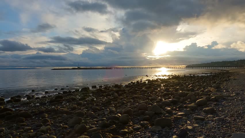 Rocky Beach and White Rock Pier on the West Coast of Pacific Ocean. Dramatic Cloudy Sunset Sky. Vancouver, British Columbia, Canada.