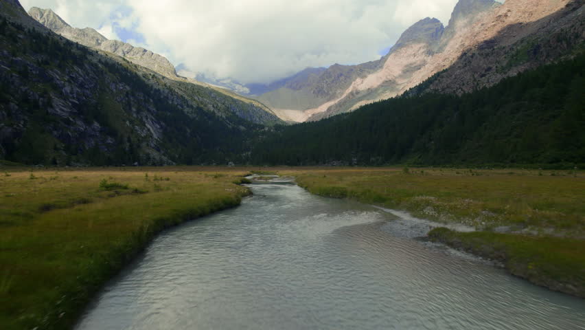 Low Flight over a Mountain River in a Valley in the Italian Alps from a Drone
