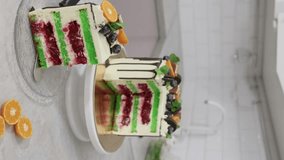 A piece of sponge cake with bright green cakes. Young female pastry chef cooking a beautiful high sponge cake, pastry chef works at home, bright kitchen, video of the process