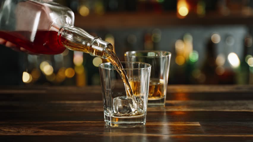 Super Slow Motion Shot of Pouring Alcohol into Glass with Ice Cubes at 1000fps with Camera Motion.