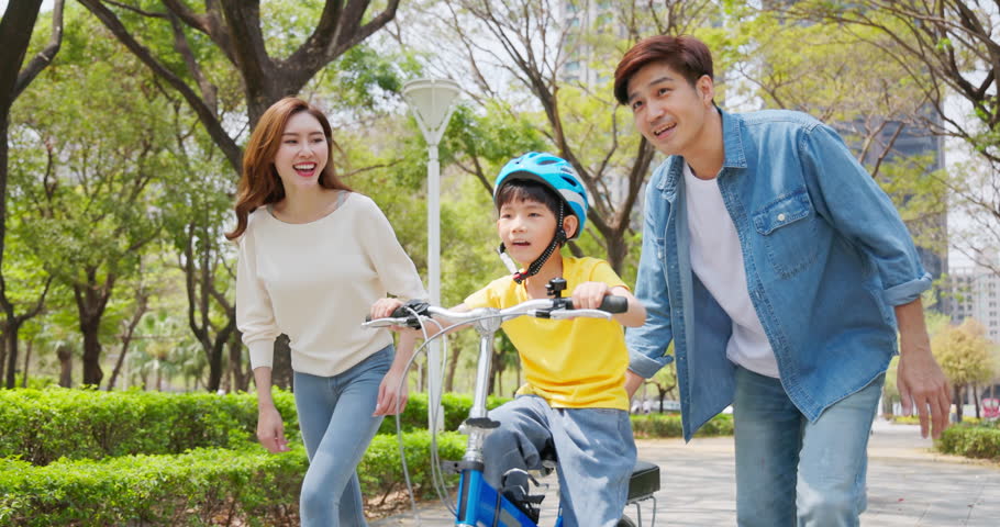 slow motion of asian parents educate child ride bicycle with encourage and support - they let go the boy successfully and happily clap hi-5 Royalty-Free Stock Footage #1104305675