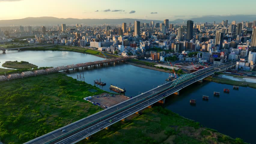 Osaka city aerial view, flying above river in downtown Osaka at sunrise with modern skyscrapers, Asian metropolis skyline. High quality 4k footage Royalty-Free Stock Footage #1104307507
