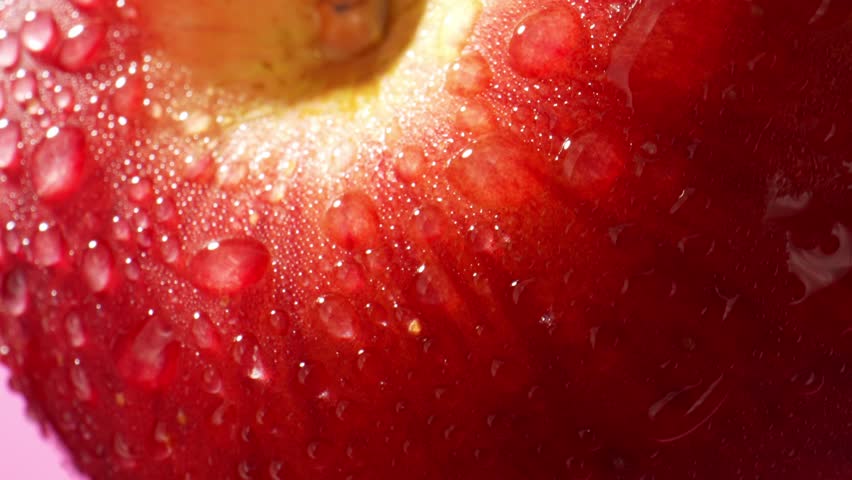 Each droplet appears like tiny, perfectly spherical jewel, reflecting the surrounding light and the apple's rich red hues. The droplets create a captivating play of light and shadow. Macro probe lens
