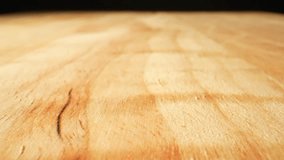 In a macro video with a probe lens, the wood texture of a chopping board comes alive with intricate grains, lines, and patterns, showcasing its natural beauty up close. Macro dolly shot. 4K HDR
