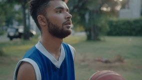 Young handsome basketball player in sportswear spinning and dribbling a ball on outdoor playground, training during golden hour. Slow motion handheld shot - Powered by Shutterstock - Get 15% off with code: PIKWIZARD15