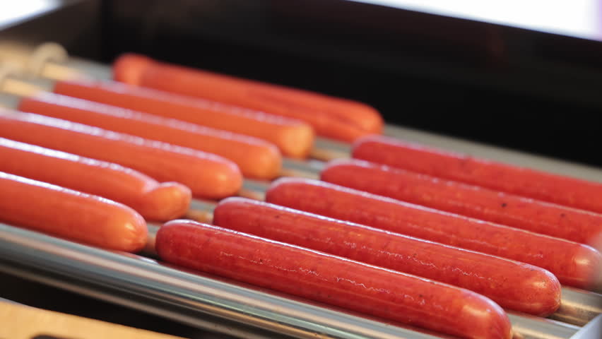 Hot Dog Sausages, Heated And Rotated. Close-up Of A Cook