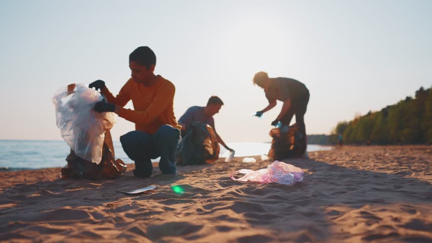 Volunteer people group on collects garbage plastic trash on tropical beach. Multinational group volunteer. Waste, bottles trash, environmental a eco ecology awareness pollution. Teamwork concept. Royalty-Free Stock Footage #1104320609