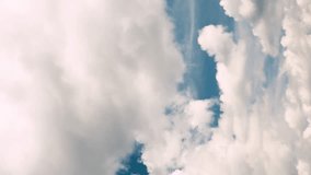 Dramatic time-lapse of moving white clouds in stormy sky. Timelapse of dynamic cloudscape in dramatic sky, vertical video