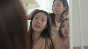 Happy Asian women friends checking makeup and hair in mirror. Concept of friendship, beauty routine, and getting ready for a party. - Powered by Shutterstock - Get 15% off with code: PIKWIZARD15