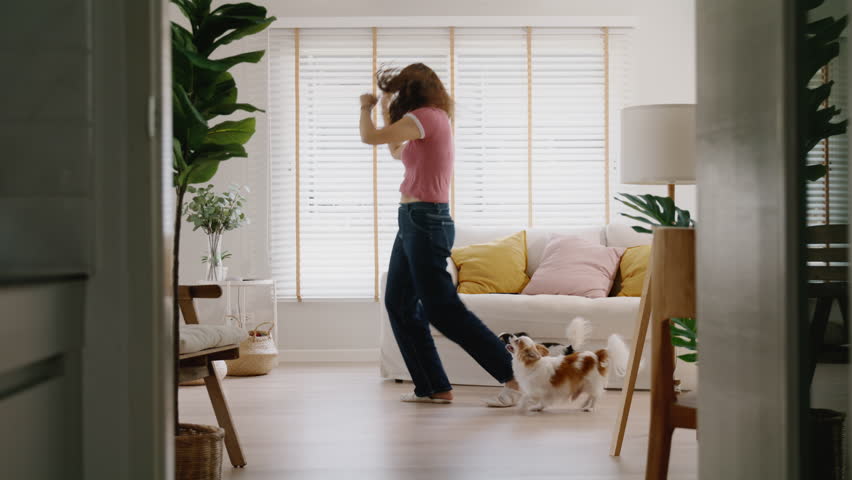 Young asia people Gen Z woman enjoy relax happy fun moving in new home. Humor laugh smile listen music funny dance crazy joy playing with cute puppy pet dog at cozy sofa life balance in youth culture. | Shutterstock HD Video #1104323367