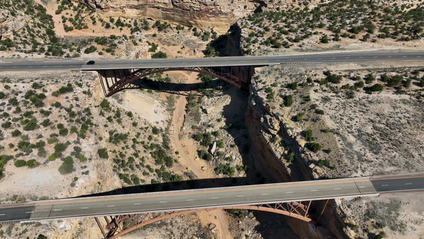 Aerial Eagle Canyon highway bridge traffic fly over Utah . San Rafael Reef geologic landscape central Utah. Eroded into tall fins, domes, cliffs, and deep canyons. wilderness desert environment.