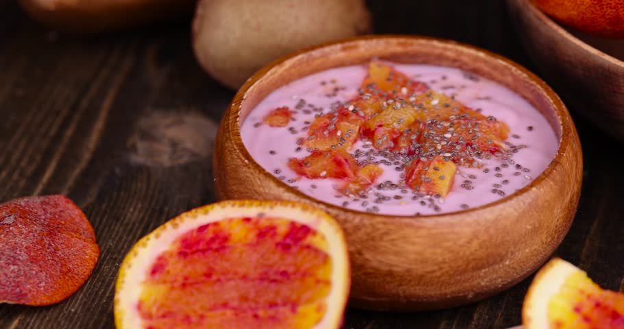 Fresh yogurt with berries and fruits with red oranges, delicious dessert yogurt with orange flavor and pieces of fruit | Shutterstock HD Video #1104324199