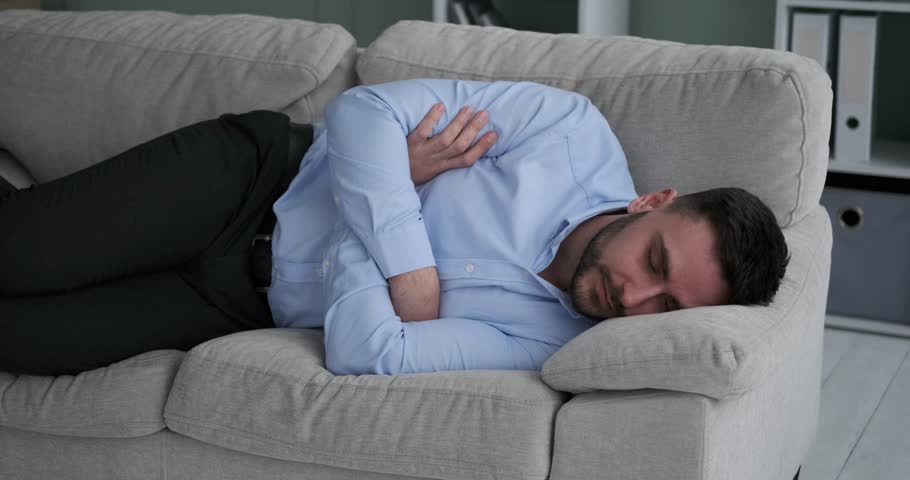 Relaxed Caucasian Office Worker Taking a Nap on a Couch in Clothes Royalty-Free Stock Footage #1104328455