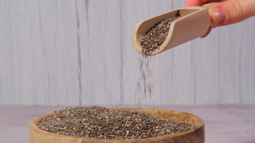 Slow motion chia seeds fall in wooden bowl. Healthy superfood rich in Omega 3 fatty acids. Dry healthy natural ingredient. Chia grains are falling | Shutterstock HD Video #1104333875