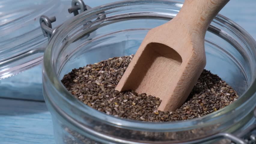 Slow motion chia seeds fall in glass jar. Healthy superfood rich in Omega 3 fatty acids. Dry healthy natural ingredient. Chia grains are falling | Shutterstock HD Video #1104333891