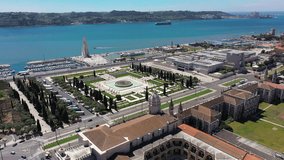 Aerial video of Praca do Imperio Garden on a sunny day with the marina and Mosteiro dos Jeronimos in the background