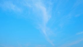 The timelapse captures the ethereal beauty of the blue sky as clouds gracefully dance across its expanse. The shifting patterns create a mesmerizing spectacle. Natural background footage. Time Lapse
