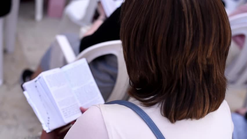 Open holy book Torah in hands of praying woman near Western Wall in Jerusalem.  pray, dream and requests to God.