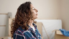 Middle age hispanic woman breathing with closed eyes at new home
