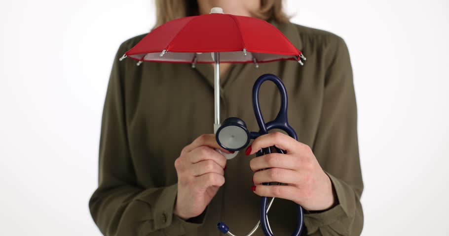 Woman hands holds doctor stethoscope and umbrella in studio | Shutterstock HD Video #1104349995