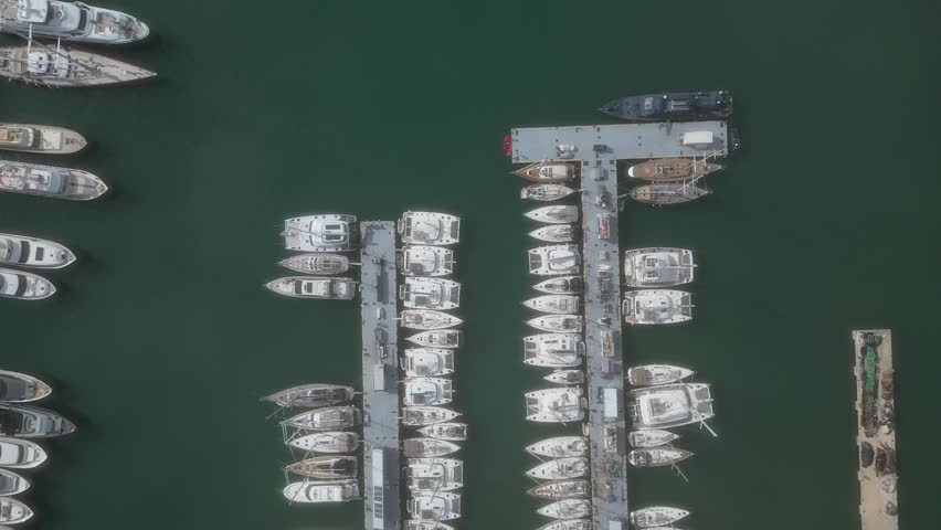 Aerial top view of boats and yachts in marina from above. Yacht parking, A marina lot, Yacht and sailboat is moored at the quay, Aerial view by drone.  | Shutterstock HD Video #1104351799