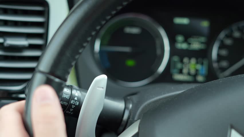 Cluj-Napoca, Cluj-Romania-05.23.2023-Mastering Gear Transitions: Detailed Close-Up of Man's Hand Operating Paddle Shifter on Car Instrument Cluster Royalty-Free Stock Footage #1104352573