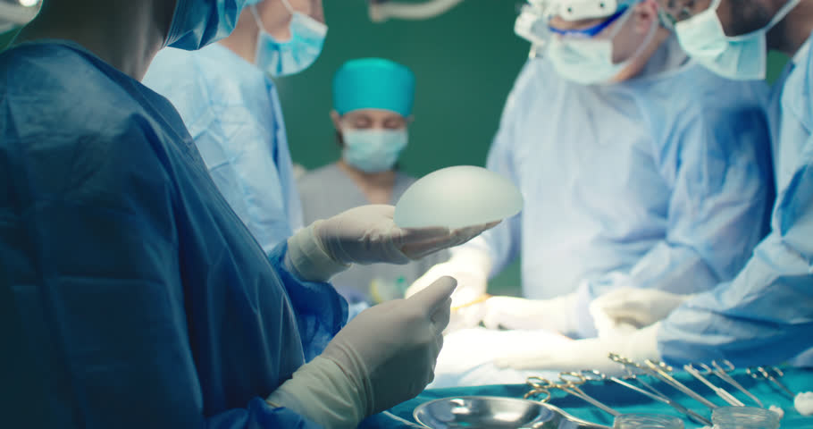 Multicultural team of professional plastic surgeons performs plastic surgery in modern private clinic. Surgeons and anesthesiologists work in operating room. Concept of medicine and treatment. Royalty-Free Stock Footage #1104354227