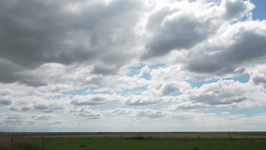 Time lapse of beautiful clouds in a blue sky over a northern Germany landscape.