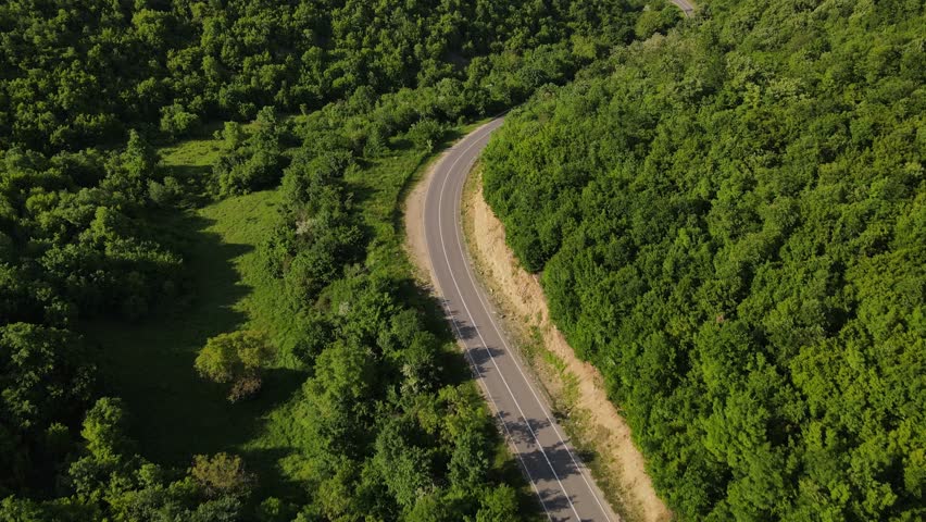 aerial view drone view on bus on the road trough the trees in mountain range in spring sunny day - Tresibaba Knjazevac in Serbia - Travel journey and vacation concept car driving Royalty-Free Stock Footage #1104359257