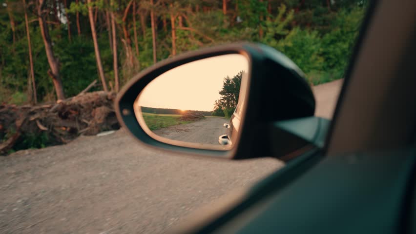 He drives a car along a dirt country road. Driving on a dusty gravel road. The concept of traveling by car in nature.