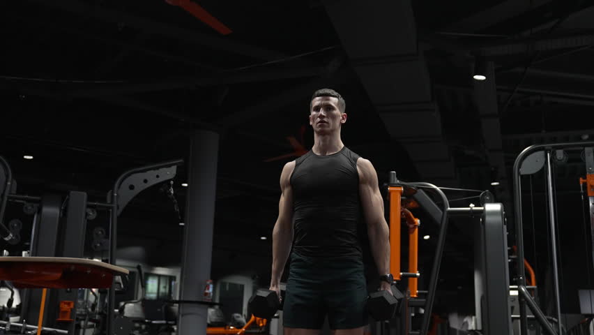 muscular athlete practicing weightlifting sport in gym with dumbbell. weightlifting sport athlete Royalty-Free Stock Footage #1104361923