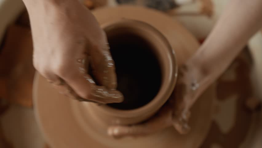 Working with clay. Top view. Man potter making ceramic vase on potters wheel from clay. Close-up in 4K, UHD Royalty-Free Stock Footage #1104362377