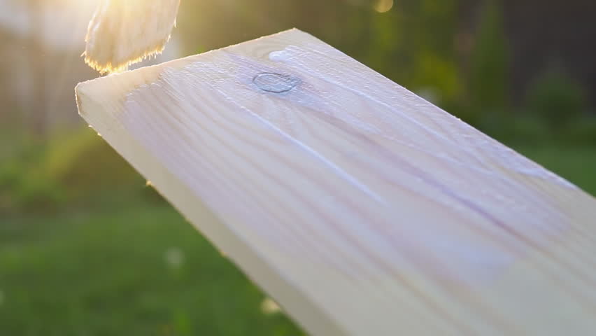Painting and caring for wood with oil at sunset. Slow motion. Royalty-Free Stock Footage #1104363345