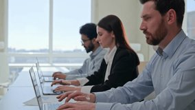 Moving shot row of multiethnic business people typing laptop pressing buttons on computer in modern office focused team managers staff businesswoman and businessmen working remote in coworking company - Powered by Shutterstock - Get 15% off with code: PIKWIZARD15