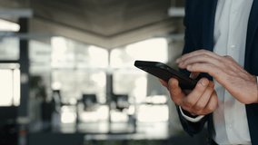Smiling mid aged business man wearing suit standing in office using cell phone. Mature businessman professional executive holding smartphone in hand checking new mobile solution on cellphone. Close up - Powered by Shutterstock - Get 15% off with code: PIKWIZARD15