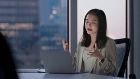 Young happy Asian woman executive team leader or hr manager having remote video conference call meeting communicating by videocall on job interview working on laptop in modern office.