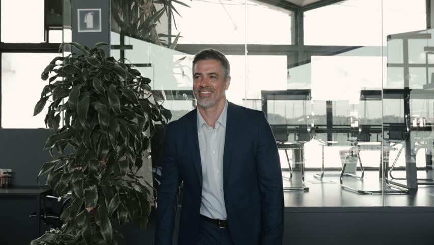 Happy middle aged business man ceo walking in office. Smiling mature confident professional executive manager, businessman owner leader wearing blue suit going along corporate space. Royalty-Free Stock Footage #1104365225
