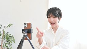 Cute woman taking pictures and streaming videos of herself on her phone.