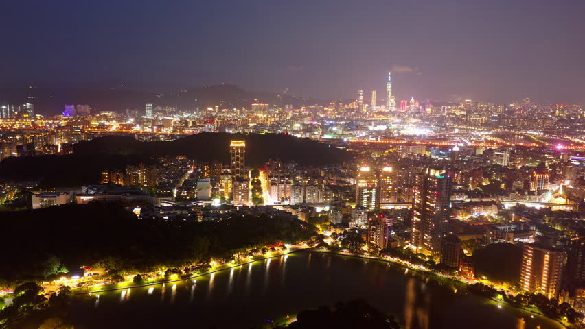 Night skyline of downtown Taipei, the vibrant capital city of Taiwan, with 101 Tower standing out amid the skyscrapers in XinYi District and residential buildings next to Bihu Park in Neihu District Royalty-Free Stock Footage #1104369853