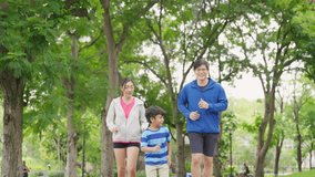 Happy Asian parent and little kids enjoy and fun outdoor lifestyle on summer vacation. Father, mother and child jogging workout exercise together at park. Family relationship and health care concept. - Powered by Shutterstock - Get 15% off with code: PIKWIZARD15