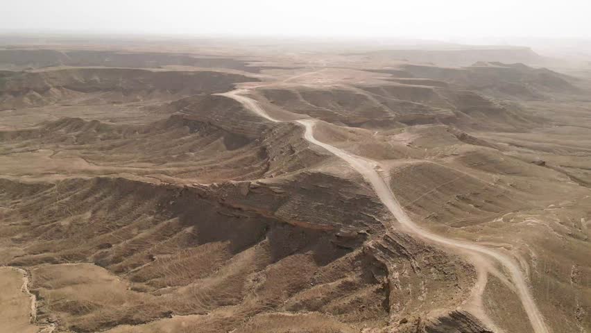 Aerial flying forward over dirt road at Edge of the World Riyadh, Saudi Arabia