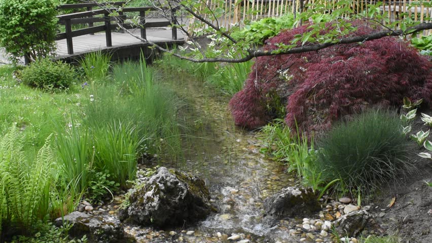 beautiful landscape with waterfall falling from stone wall in japanese style landscape park. Selective focus.