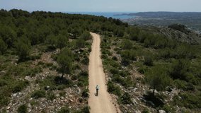 Gravel cycling adventure.Sport motivation drone video.female cyclist riding between the mountains.Alicante region.